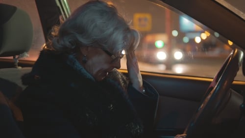 Müde Frau mittleren Alters sitzt während der Fahrt im Auto