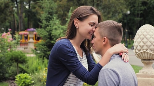Young Couple Sharing Tender Moment in Sunny Park
