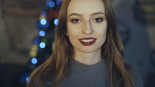 Smiling Woman in Front of Christmas Tree Lights