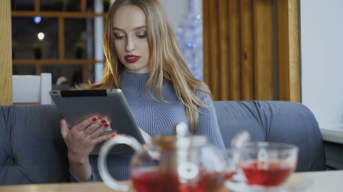 Young Woman Using Tablet in Cafe