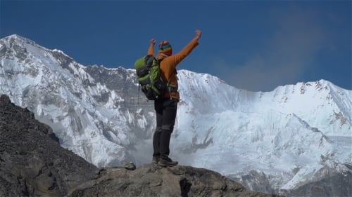 Triumphant Hiker Reaches Snowy Mountain Peak