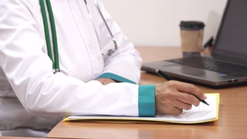 Woman Doctor Writing Notes in Office Setting