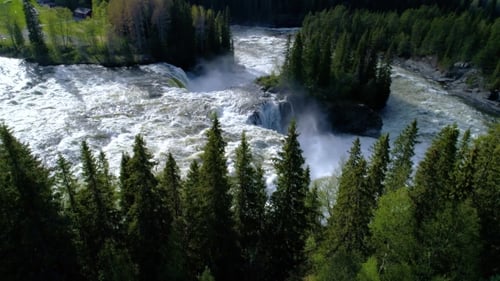 Aerial View of Waterfall Flowing Through Forest