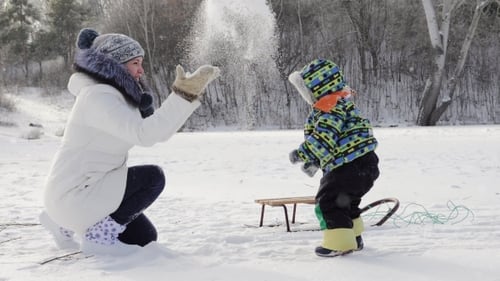 Mutter mit Baby im Winterschnee.
Ferien