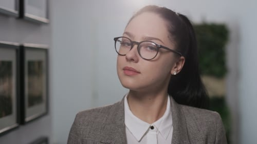Confident Young Woman in Blazer and Glasses