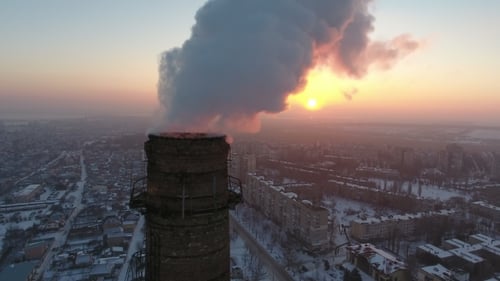 Aerial Shot of a Big Industrial Tower with White Smoke at Sunset in Winter