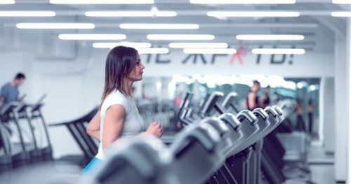 Adult Woman Runs on Treadmill at the Fitness Centre
