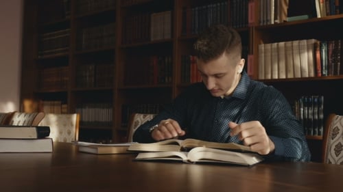 Man Reads Books in Classic Library Setting