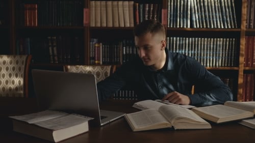 Young Adult Studying with Laptop and Books
