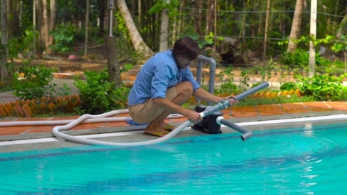 Man Assembles a Pool Vacuum Cleaner Providing Service and Maintenance of the Pool