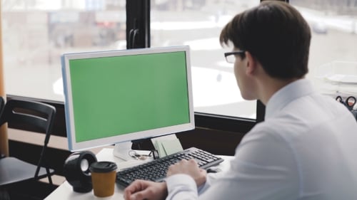 Young Man Works with Pc with Green Screen and Keyboard