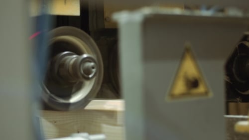 Wood being cut with automated saw in factory