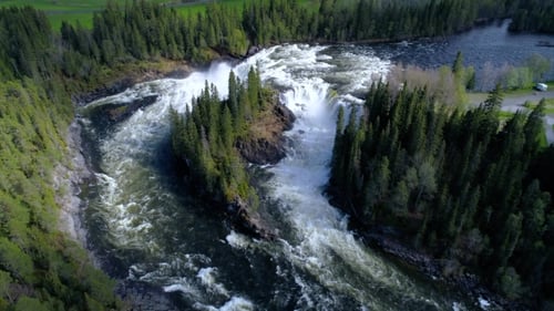 Aerial View of Waterfall Flowing Through Forest