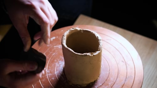 de mains travaillant de la pâte à modeler sur la roue du potier. Potter façonne le produit en argile à l'aide d'outils de poterie placés sur le
