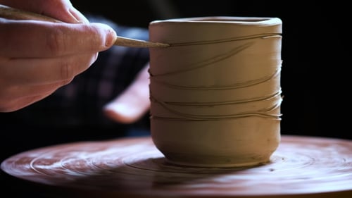de mains travaillant de la pâte à modeler sur la roue du potier. Potter façonne le produit en argile à l'aide d'outils de poterie placés sur le