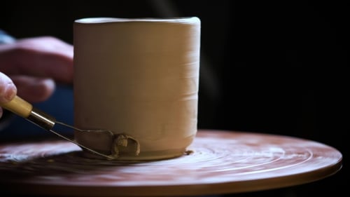 de mains travaillant de la pâte à modeler sur la roue du potier. Potter façonne le produit en argile à l'aide d'outils de poterie placés sur le