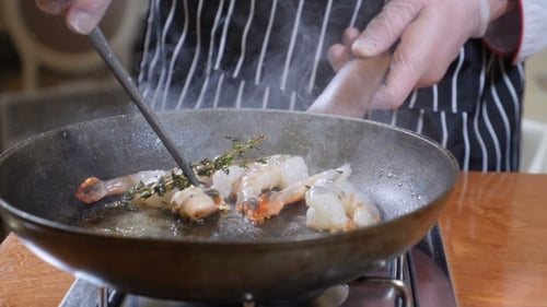 Chef Cooking Shrimp with Thyme in Pan
