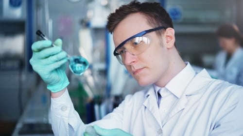 Scientist Inspecting Liquid in Lab Flask