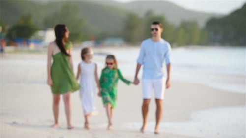 Family of Four Walking on White Beach
