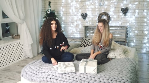 Two Women Celebrating Christmas with Gifts on Bed