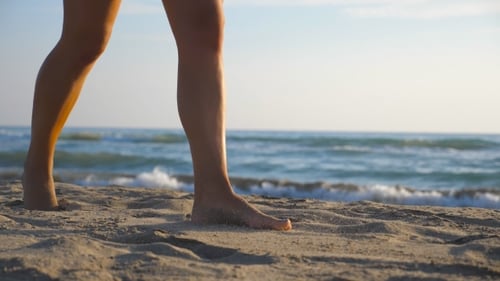 of Female Foot Stepping on the Sand with Sea Waves at Background Beautiful Woman Walking on the