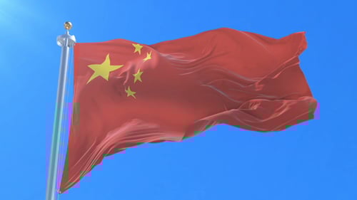 Waving Chinese Flag against Clear Blue Sky