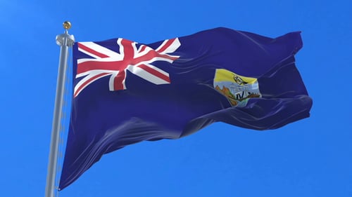 Flag of Saint Helena Waving in Slow Motion Against Blue Sky