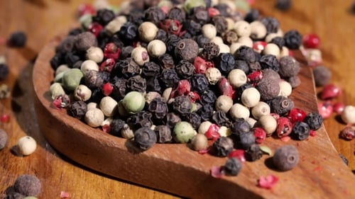 Colorful Peppercorns Spilling from Wooden Spoon