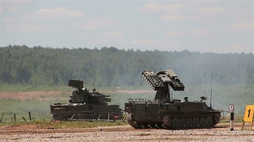 Two Military Vehicles Parked in a Grassy Field