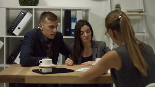 Happy Couple Signing a Contract Together at Office