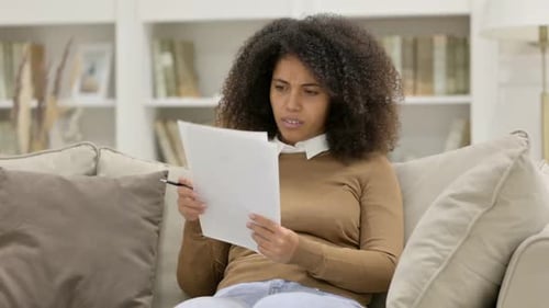 Young Adult Woman Reading Document with Negative Emotion