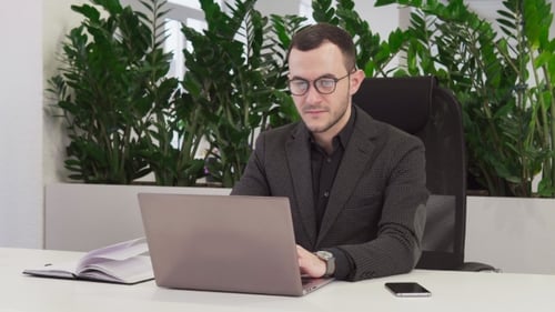 Young Business Man in Suit Working on Laptop in Office