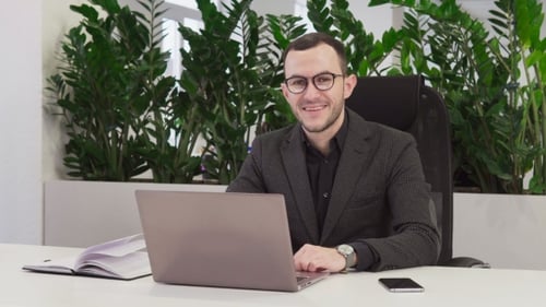 Successful Businessman in Suit Smiling at Workplace in Office