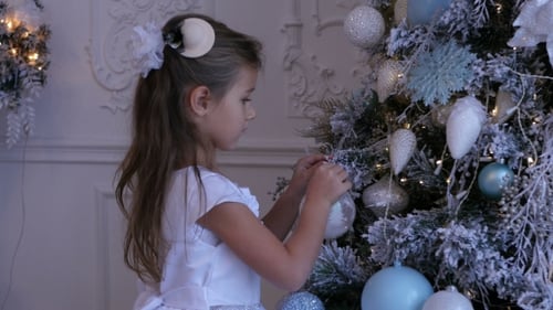 Child Decorates Christmas Tree with Ornament