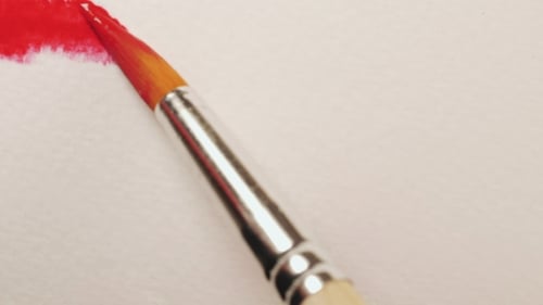 Paintbrush Moves Across Canvas Leaving Red Brush Strokes of Paint.