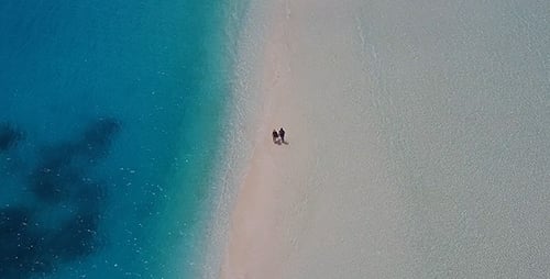 Couple Walking Along Incredible Sandbank in the Maldives