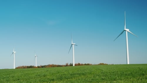 Mehrere Windturbinen auf einem grünen Hügel