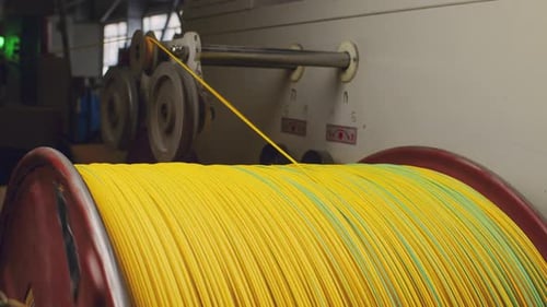 Yellow Wire Winding Around Industrial Spool