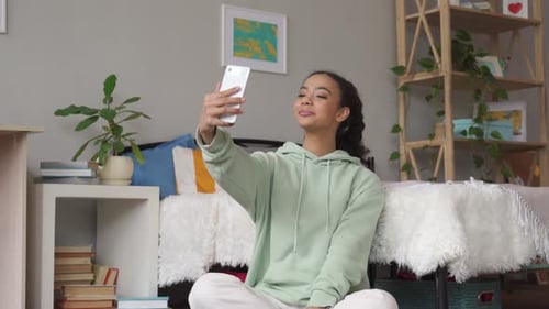 Young Woman Taking a Selfie in Bedroom