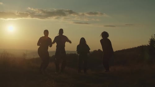 Glückliche sorglose, vielfältige Freunde, die Spaß beim Springen auf den Berggipfel