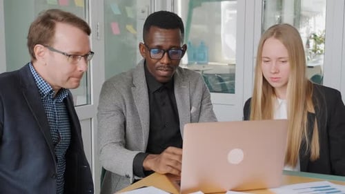 Drei Geschäftsleute beraten sich im Büro und diskutieren über das Projekt