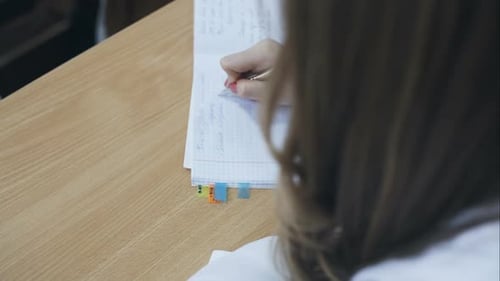 A Student Takes Notes in His Notebook During Lectures
