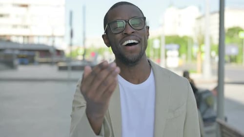 Smiling Man Beckons Toward Camera
