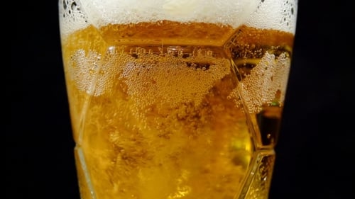 Frisches Bier in einen Glasbecher gießen
