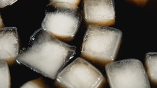 Ice Cubes Floating in Dark Liquid, Close Up