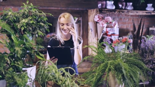 Happy Woman Working in Flower Shop on Phone