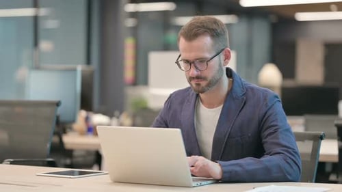 Middle Aged Businessman Working on Laptop in Office