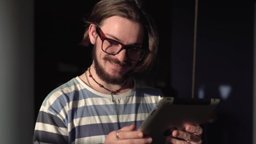 Man with Glasses Using Tablet Indoors