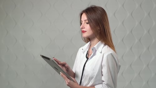 Female Doctor Uses Tablet in Hospital Environment
