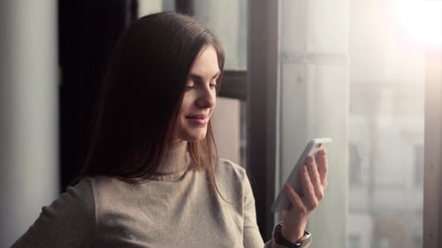 Woman Using Mobile Phone Indoors